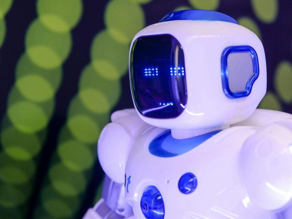 Close-up of a modern humanoid robot with glowing blue features on a green abstract background.